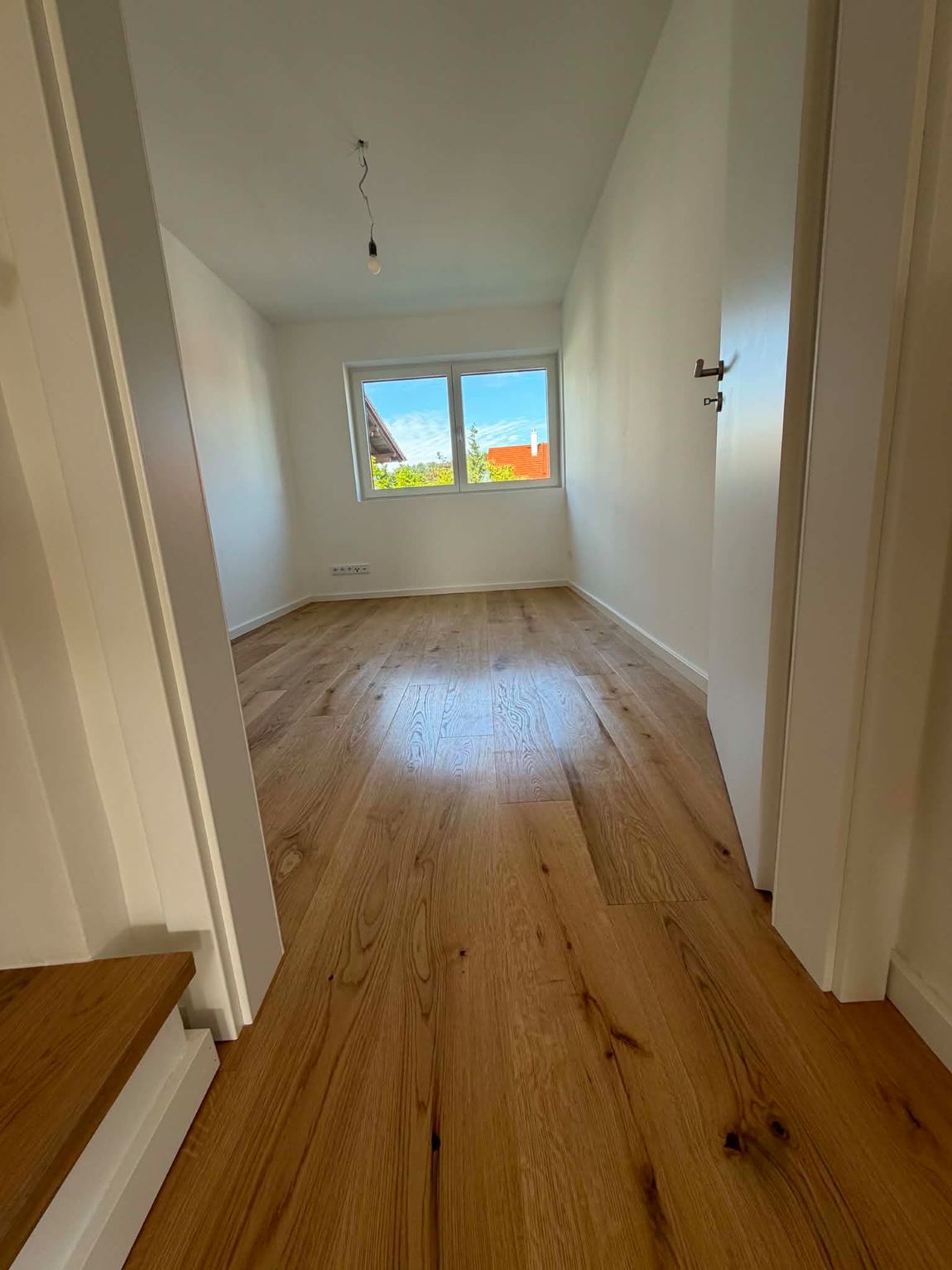 Leere Wohnung nach der Bauendreinigung mit sauberem Eichenparkett