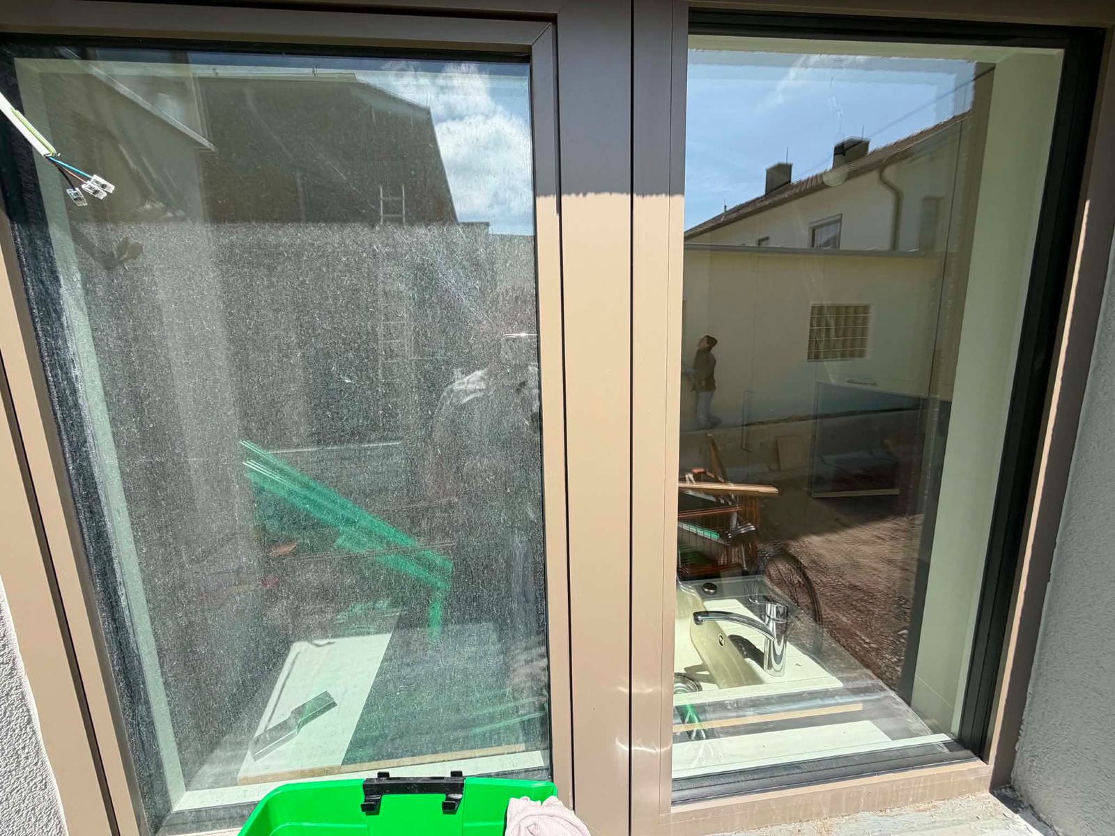 Fensterfront nach der Bauendreinigung: der linke Flügel noch mit Bauschleier, der rechte Flügel bereits streifenfrei gereinigt